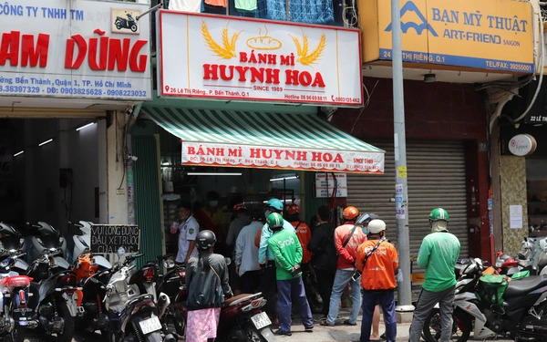 The daily crowd of motorbike shippers waiting for orders at Banh Mi Huynh Hoa